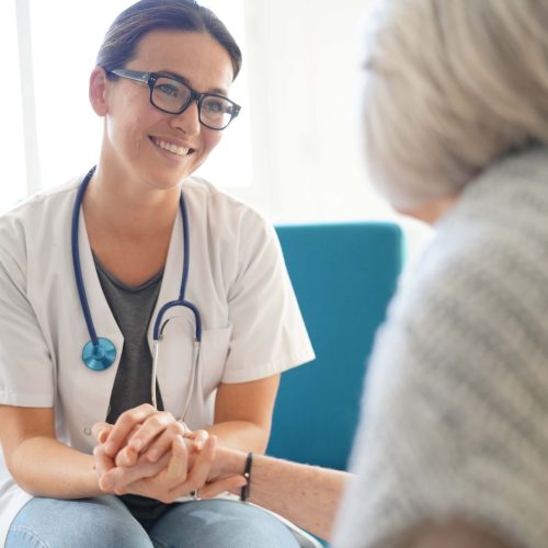 Young doctor comforting senior woman